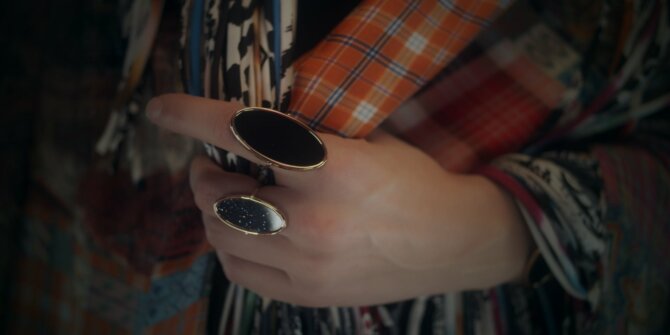 Hand wearing two large black stone rings against patchwork fabrics – Ginette NY Ajna jewellery film