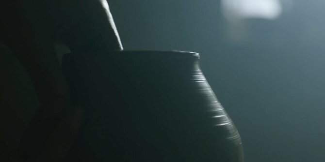 Silhouette of a clay pot turning on the wheel, misty side light – At the Heart of Craftsmanship