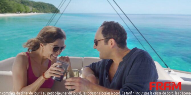 Couple toasting on the deck of a catamaran in the Caribbean sun – FRAM Martinique commercial