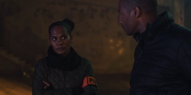 Female officer with a police armband facing a colleague at night – OPJ Season 5 Double Lady