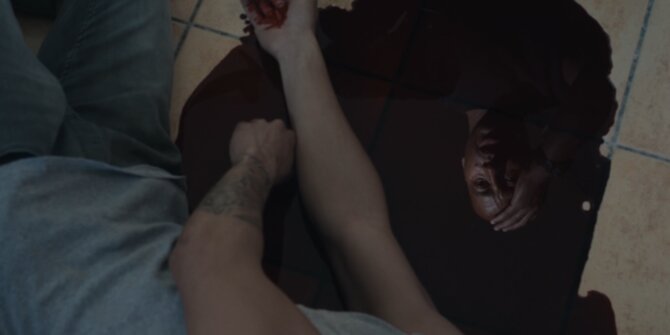 Top shot of a man pressing on a wound of a person lying on tiles – OPJ Season 6 Forbidden Fruit
