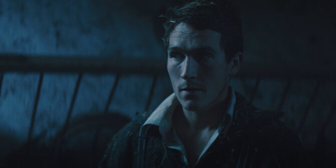 Young man in a dark barn, face lit by cold moonlight – Rhinozeros feature film