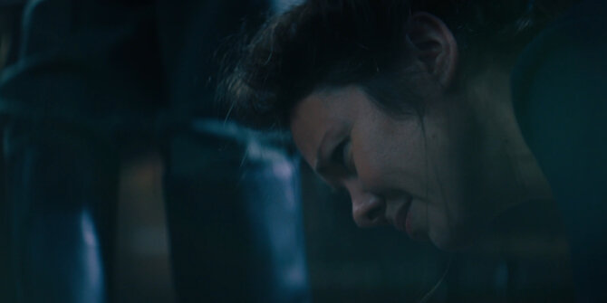 Woman in distress bent over in the dark, blue night light – Rhinozeros feature film