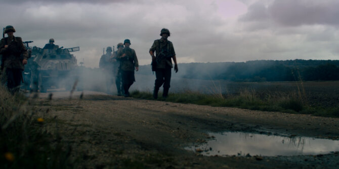 Soldiers and an armoured vehicle advancing through smoke on a country road – Rhinozeros